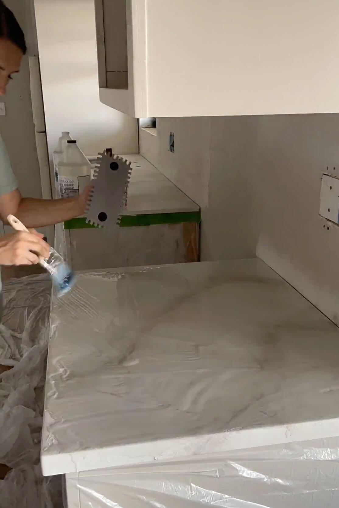 Spreading epoxy on DIY kitchen countertop.